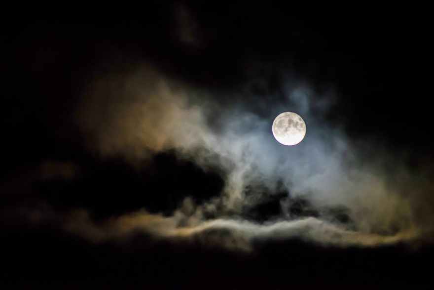 night sky with clouds around a full moon